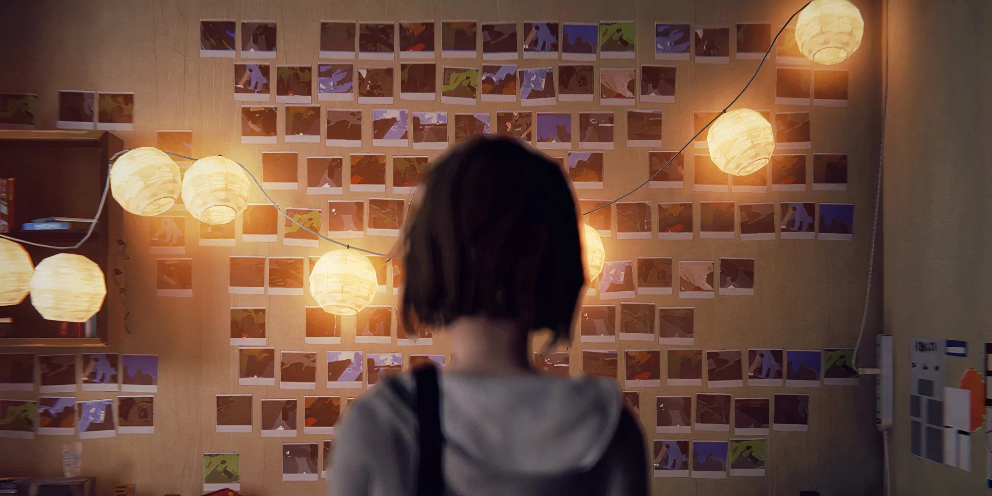 Nhân vật chính Max Caulfield của Life is Strange đứng quay lưng trong căn phòng được trang trí bằng ảnh polaroid và đèn dây