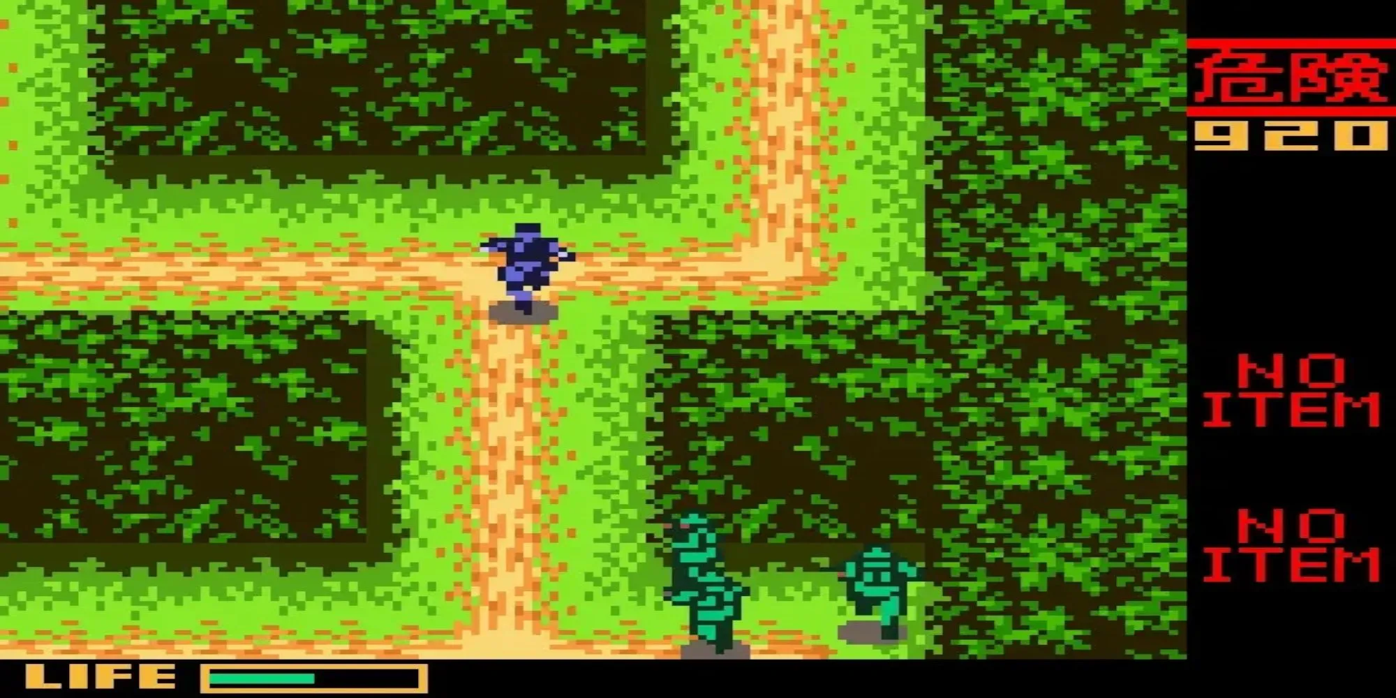 Snake đang ẩn mình sau vật cản trong game Metal Gear Solid trên Game Boy Color với góc nhìn từ trên xuống