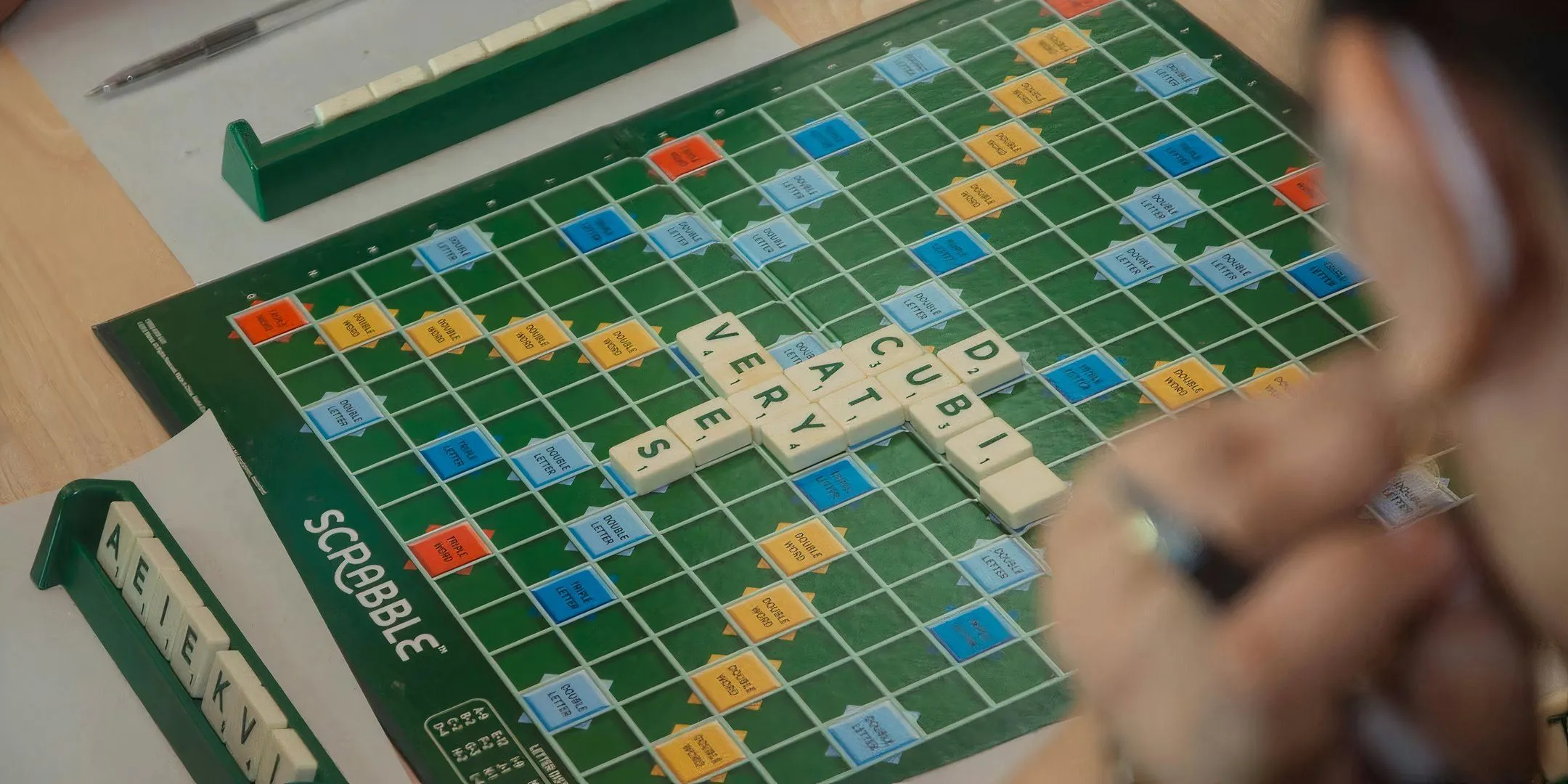 Bàn chơi Scrabble với các ô điểm thưởng và các quân cờ chữ cái được sắp xếp thành từ, gợi lên không khí đấu trí và sáng tạo ngôn ngữ.