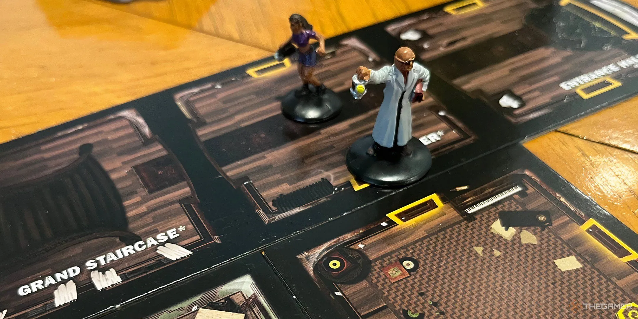 Bảng chơi game Betrayal at House on the Hill với các mảnh phòng được ghép lại ngẫu nhiên tạo thành một ngôi nhà ma ám, cùng với các lá bài và quân cờ nhân vật, thể hiện sự kịch tính và khám phá.