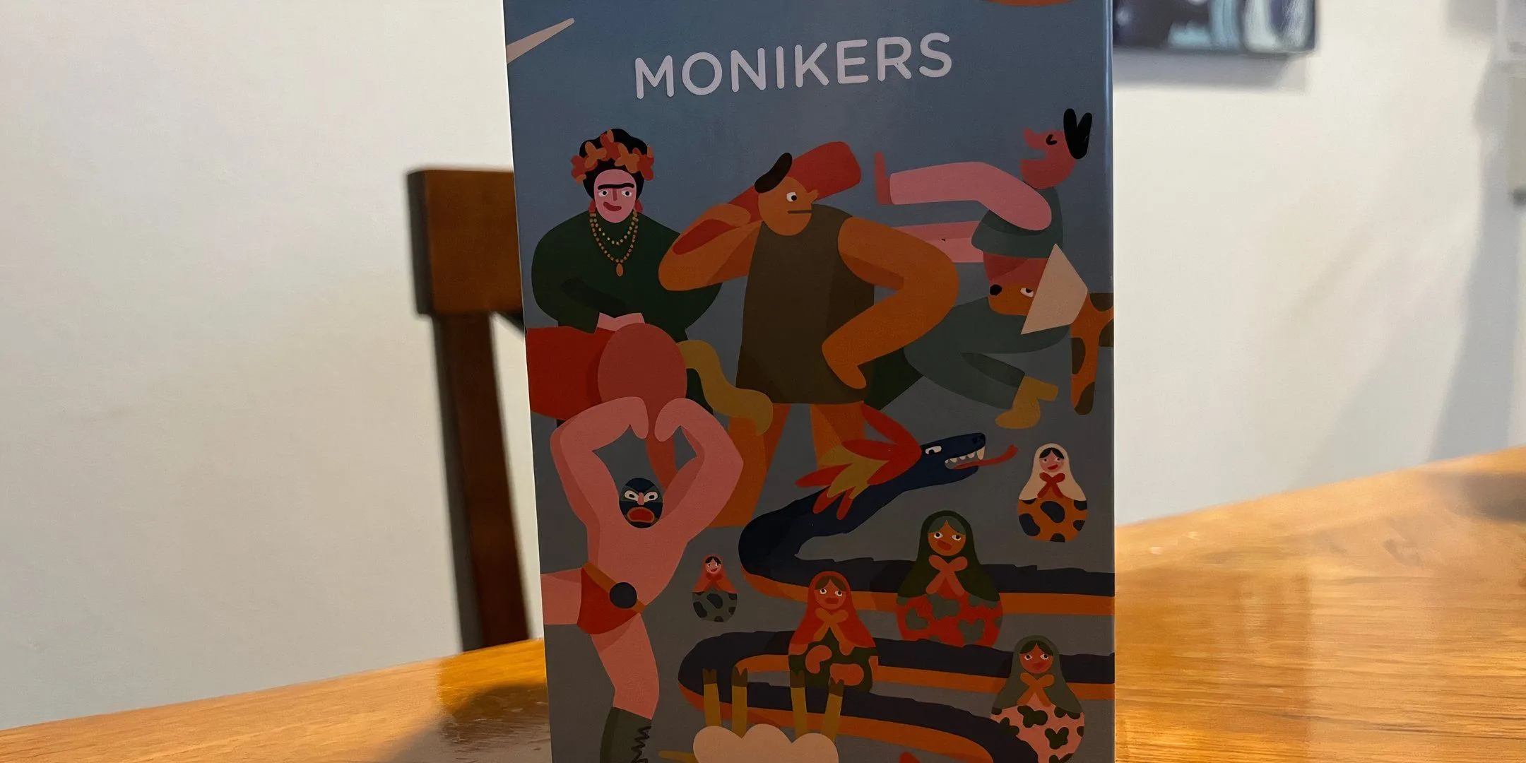 Bìa hộp game Monikers, một trò chơi đoán từ vui nhộn thường được yêu thích trong các buổi tụ tập bạn bè.
