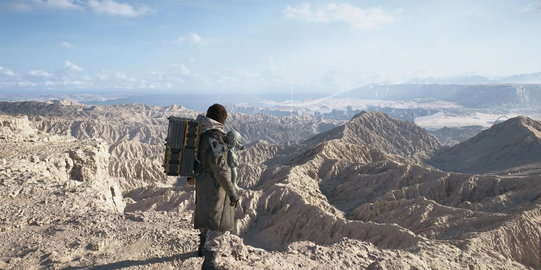 Sam Porter Bridges đứng trên đỉnh núi Mexico, chuẩn bị cho hành trình vượt địa hình trong Death Stranding 2.